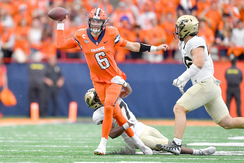 Syracuse quarterback Garrett Shrader, left, throws the ball while pressured by Purdue safety Chris Jefferson during Saturday&rsquo;s non-league game in Syracuse. The Orange won 32-29.