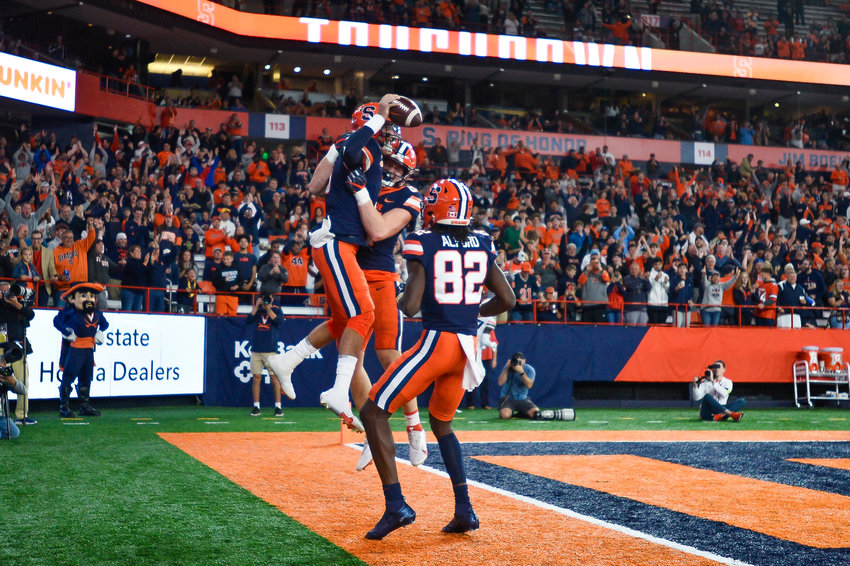 Syracuse quarterback Garrett Shrader (6) celebrates with tight end Maximilian Mang and wide receiver Damien Alford (82) after scoring against Virginia during the first half on Friday night in Syracuse. The Orange won 22-20.