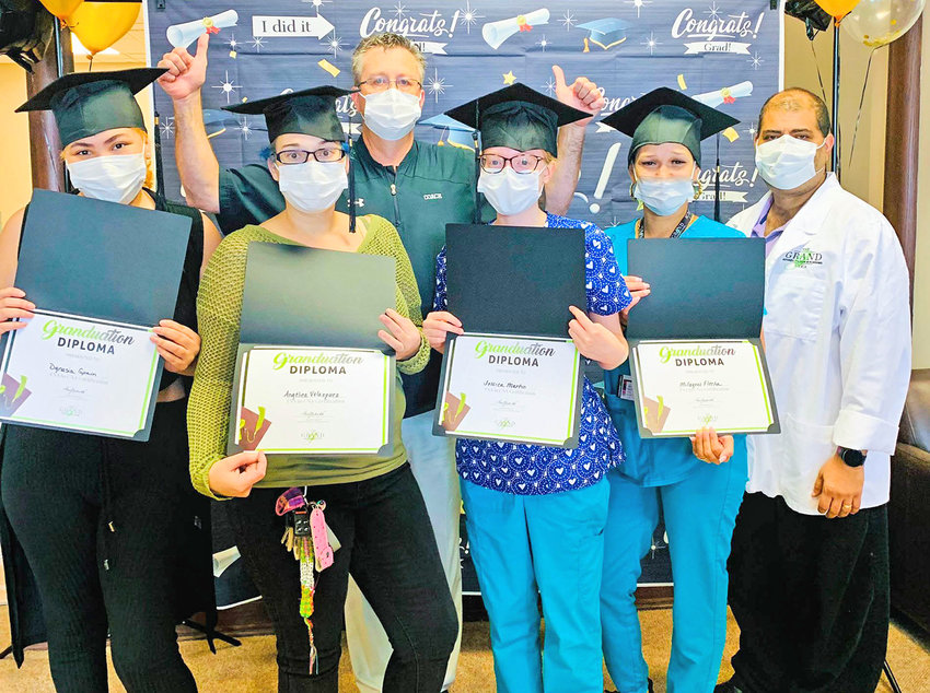 Graduates of the certified nurses aide program pose for a photo with their diplomas at The Grand at Utica, 1657 Sunset Ave., on Thursday.