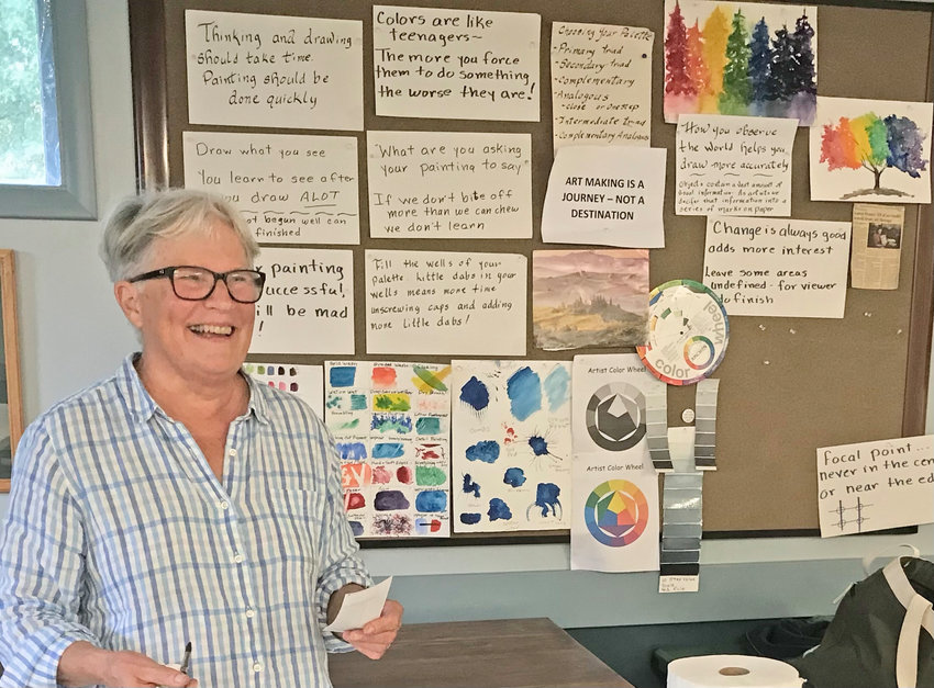 Local watercolor artist and instructor Laura Diddle stands in front of a collection of motivating signs Thursday during her class at the Sherrill-Kenwood Free Library in Sherrill.