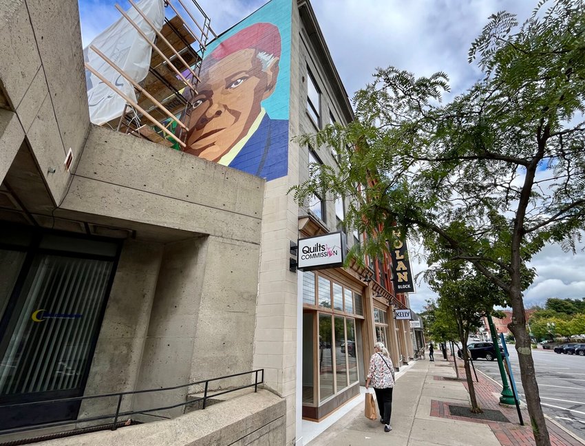 A mural of Harriet Tubman and her life peeks out from behind scaffolding above the concrete building at 63 Genesee St. in Auburn. The mural was unveiled on Saturday, Sept. 24, with hopes to help educate and inspire viewers.