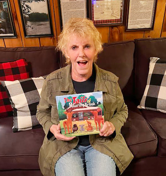 Boonville resident June Bender holding her recently published children&rsquo;s book, &ldquo;The Tails of Roaring Brook.&rdquo; Bender&rsquo;s stories are based on those she tells her grandchildren, which are inspired by the wildlife she and her husband, Rick Bender, observe at their real-life Roaring Brook Camp.