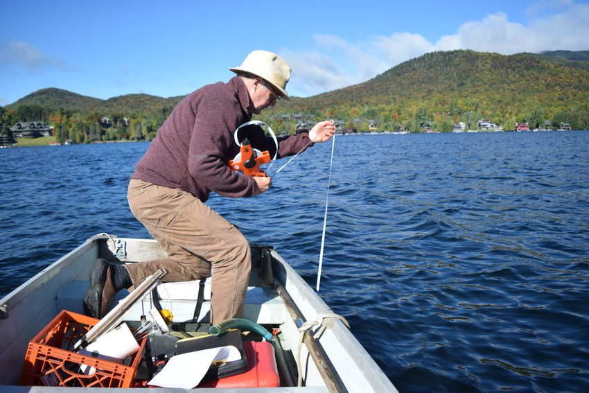 Mark Wilson, a member of the Lake Placid Shore Owners&rsquo; Association, tests the clarity of Lake Placid&rsquo;s water with a Secchi disk on Sept. 24. He and other local citizen scientists say the water quality of the lake is deteriorating.