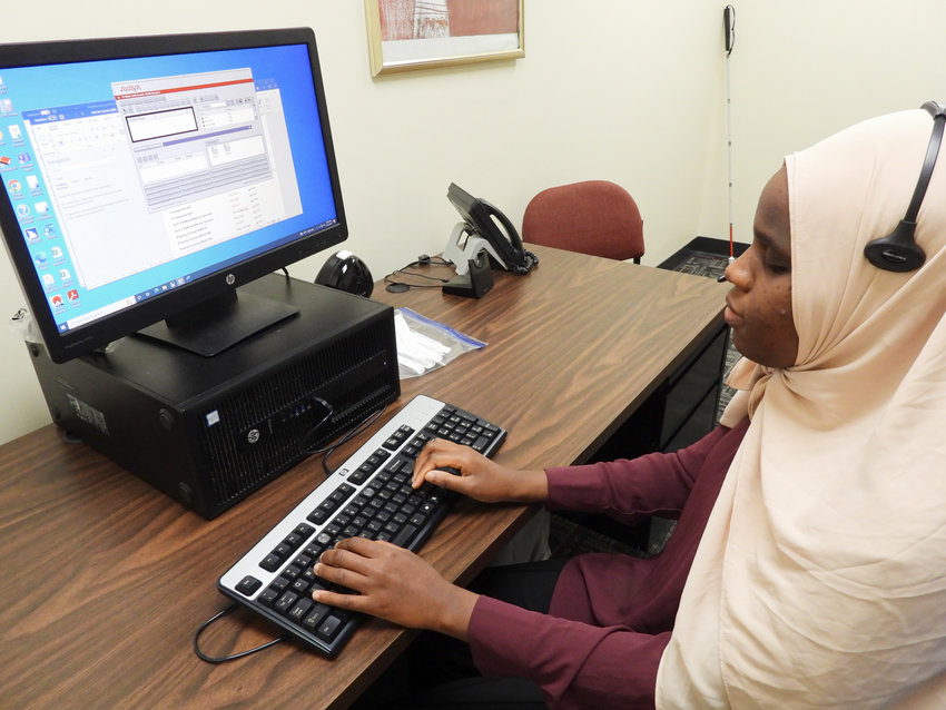Makka Djouma, a Sudanese immigrant refugee who&rsquo;s blind, works at the Mohawk Valley Community Action Agency in Utica as a telephone operator and receptionist.(Sentinel photo by Charles Pritchard)