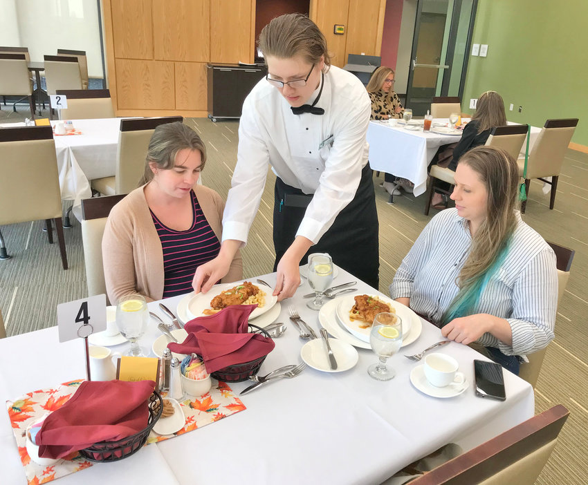 Mohawk Valley Community College culinary arts management student Tyler Hall, standing, serves Katie Voce, left, and Candice Docherty Wednesday at the Dining and Community Hall on the Rome campus.