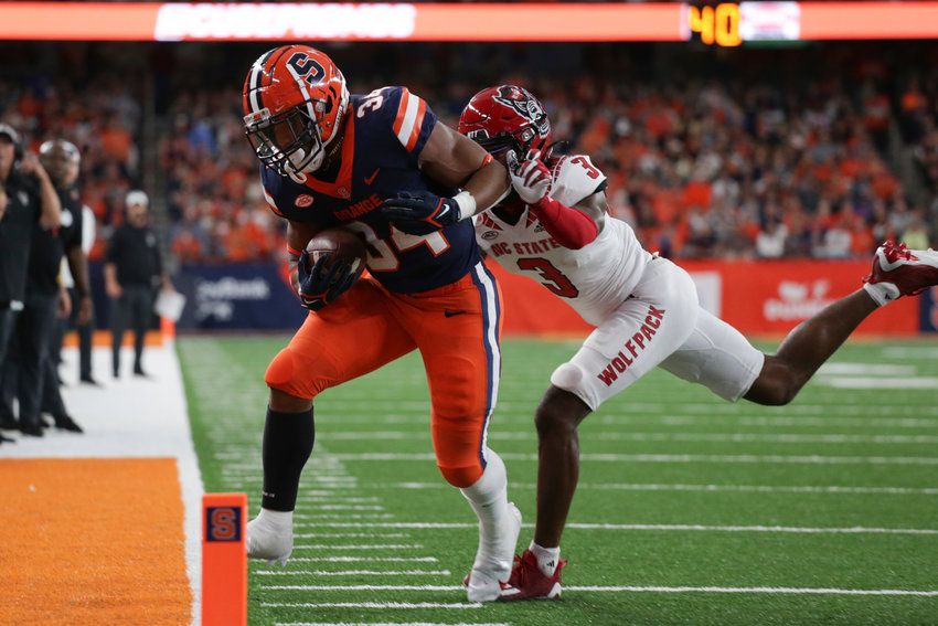 Syracuse running back Sean Tucker, left, is tackled out of bounds by North Carolina State cornerback Aydan White during the first half on Saturday in Syracuse.