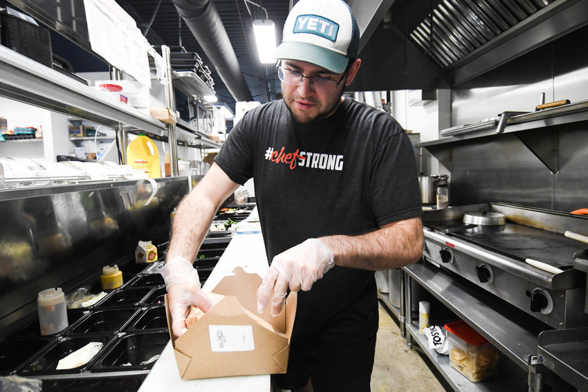 Matt Cardello prepares a tuna melt in the kitchen at The Balanced Chef in Rome. In addition to weekly meal prepping customers can stop in for a quick bite to eat and make to go orders. (File photo