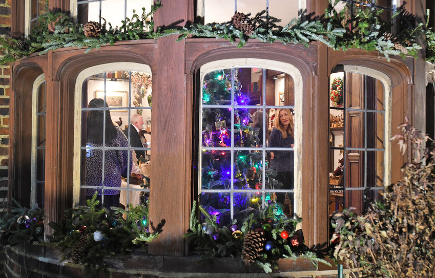 Patrons look over an array of holiday ornaments and handcrafted decorations in this view from the outside, looking into the Rome Art and Community Center, 308 W. Bloomfield St., during a past Holiday House gala.