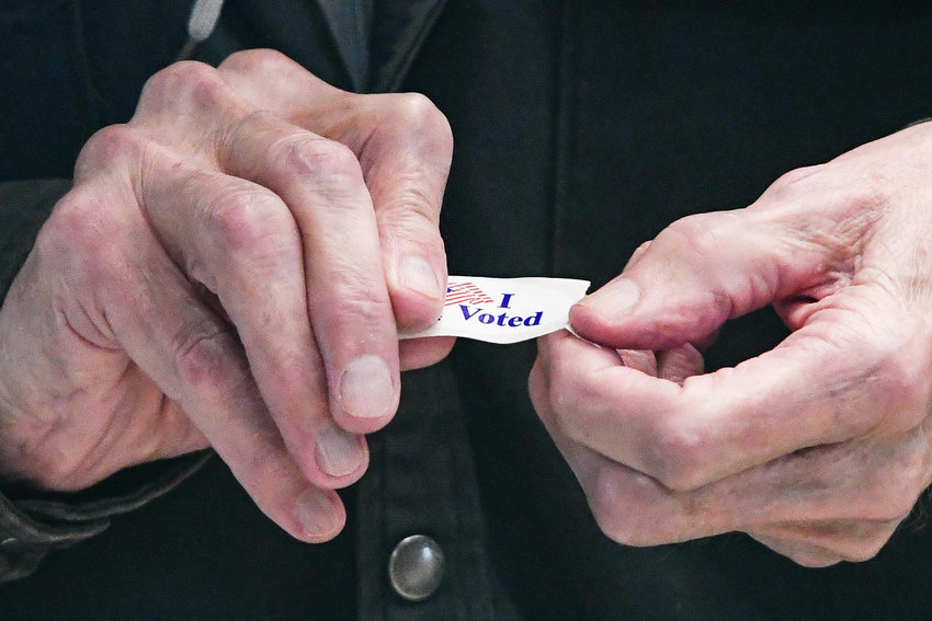 A man prepares to put on an &quot;I Voted&quot; sticker after casting hil ballot at Utica City Hall on Tuesday, Nov. 8. Oneida County election commissioners reported a busy day at the polls, with some 4,500 to 4,700 voters each hour going to cast their ballots across the county.