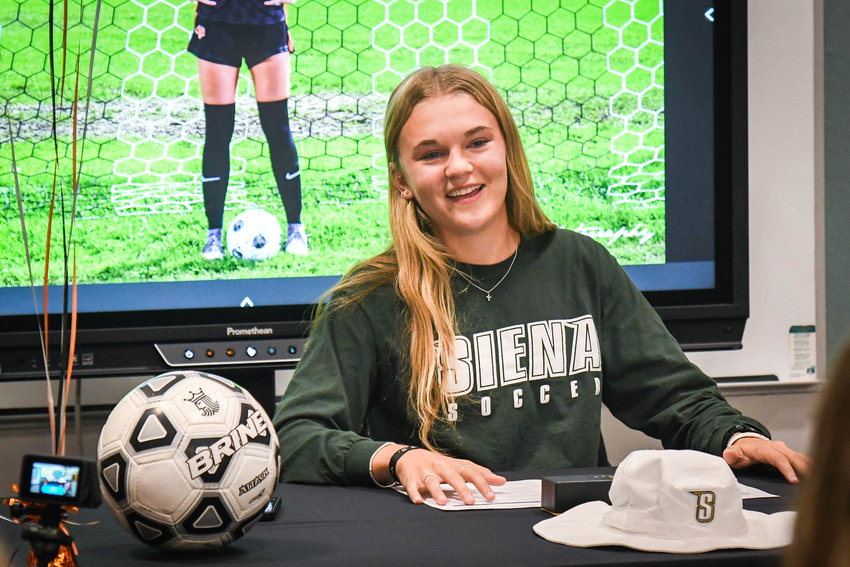 Remsen&rsquo;s Julia Dening signs a letter of intent on Wednesday to play women&rsquo;s soccer at Siena College in the library of Remsen Junior-Senior High School.