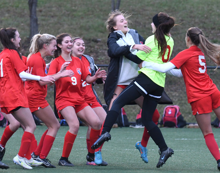 New Hartford goalkeeper Savannah Cole celebrates with teammates after making the save in penalty kicks sixth round Saturday afternoon at Tompkins Cortland Community College. New Hartford won 6-5 on penalty kicks to advance to the state Class A championship game Sunday.