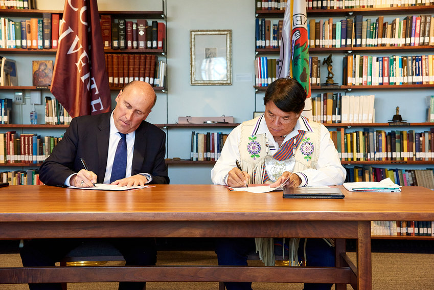 Colgate University President Brian Casey, left, and Oneida Indian Nation Representative Ray Halbritter sign proclamations for the repatriation of the Oneida Nation&rsquo;s belongings from the university&rsquo;s Longyear Museum of Cultural Anthropology on Wednesday.