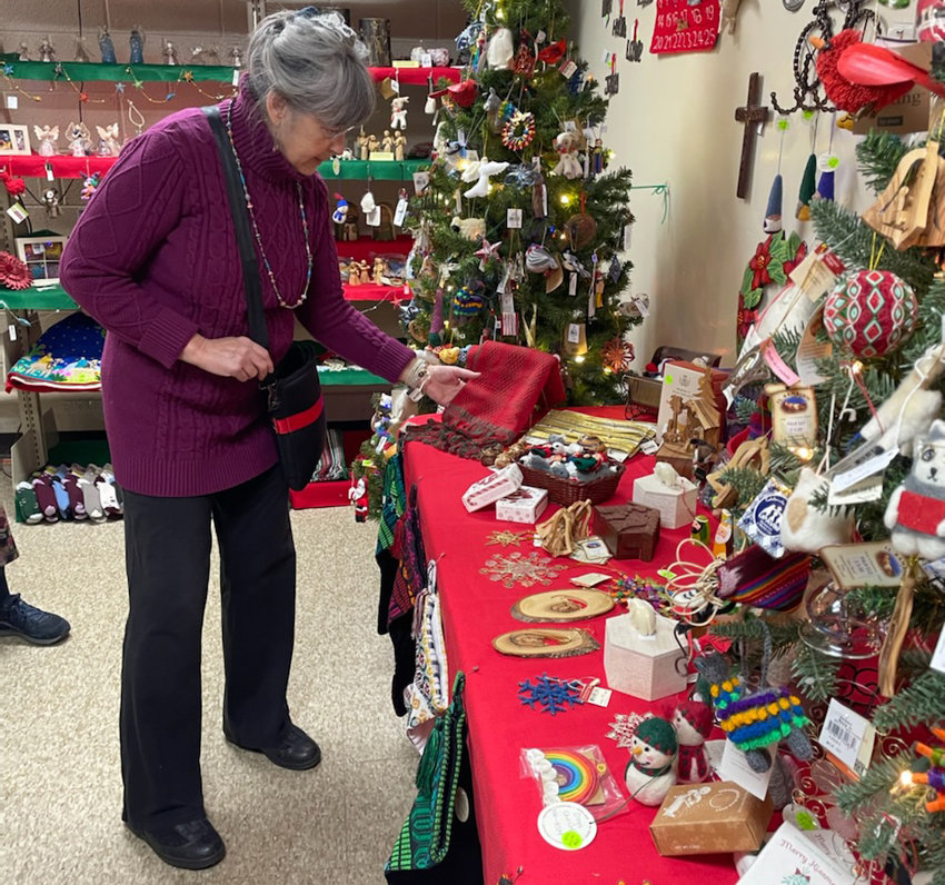 Lauralyn Kolb, director of the Fair Trade Shop at Stone Presbyterian Church, 8 S. Park Row, Clinton, displays a table runner and other holiday-themed gifts for purchase at the shop.