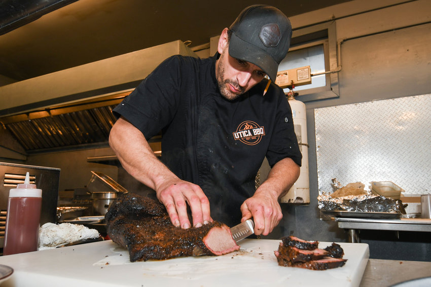 Chance Borawski slices up a piece of brisket in the kitchen at Utica BBQ at 224 Roosevelt Drive in Utica, on Friday, Nov. 11.