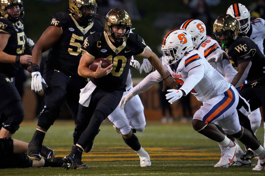Wake Forest quarterback Sam Hartman scrambles for a first down against Syracuse during the first half on Saturday night in Winston-Salem, N.C. The Orange lost 45-35.