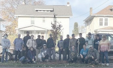 Volunteers pause from their efforts to help plant 26 new trees in Utica&rsquo;s neighborhoods for a photo last week.