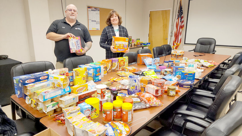 Utica Center for Development, Inc. Founder/Executive Director Vincent Scalise and Assemblywoman Marianne Buttenschon, D-119, Marcy, stand with food collected for local National Guard members currently serving in Africa.