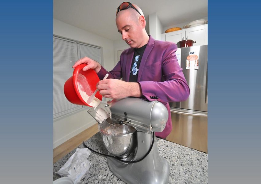 James Daino adds flour to his recipe of chocolate chip cookies Nov. 8 at his home in Rome.