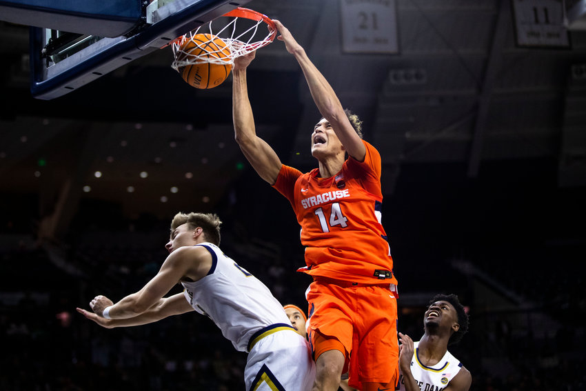 Syracuse's Jesse Edwards (14) dunks over Notre Dame's Dane Goodwin, left, as Trey Wertz, right, watches during Saturday afternoon's game in South Bend, Ind. The Orange won 62-61.