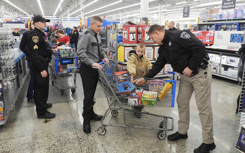 A youngster looks over his treasurers during the Madison County Shop with a Sheriff event on Saturday, Dec. 3, at the Oneida Walmart, 2024 Genesee St.