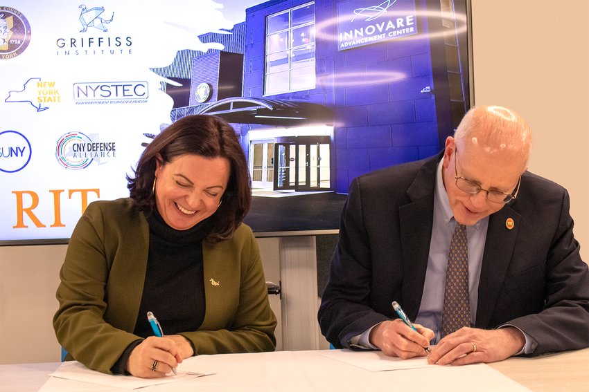 Heather Hage, president &amp;amp; CEO of Griffiss Institute and David C. Munson Jr., president of the Rochester Institute of Technology, sign a memorandum of understanding at the Innovare Advancement Center on Tuesday.