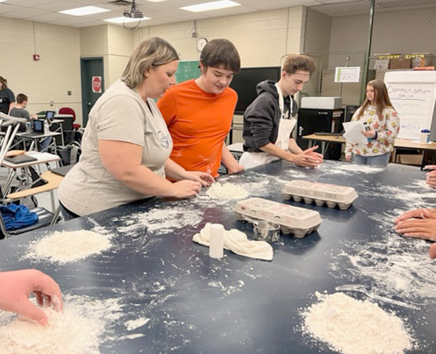 Herkimer-Fulton-Hamilton-Otsego BOCES READiTEC teacher Brandie Reid, left, works with  ninth graders Raymond Colvin from the Little Falls City School District, center, and Collin Zaengle  from the Central Valley Central School District recently while students participated in a culinary unit.