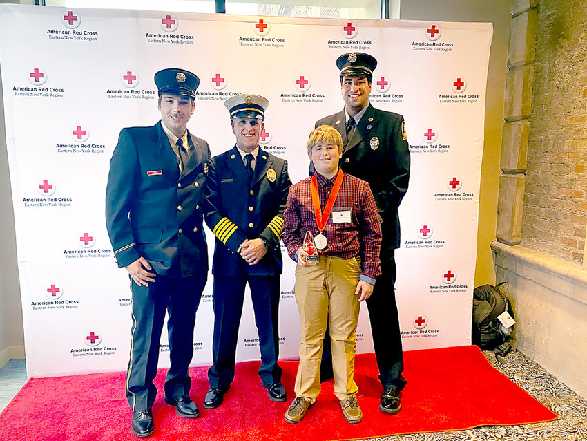 Herkimer Central School District sixth grader Brett Saunders, front, poses with, from left, former Herkimer firefighter Tejay Chilluffo, Herkimer Fire Chief Michael Moody and Herkimer firefighter Dan Mabbett after receiving the Youth Good Samaritan Award Dec. 7 at the American Red Cross Real Heroes Celebration at the Marriott in downtown Syracuse.