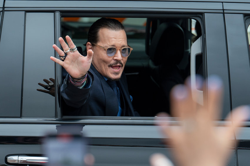 Actor Johnny Depp waves to supporters as he departs the Fairfax County Courthouse during his high-profile libel lawsuit against ex-wife Amber Heard, on May 27, 2022 in Fairfax, Va.