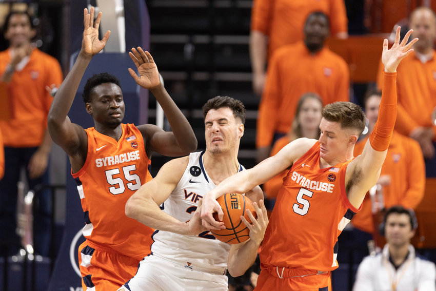 Virginia's Francisco Caffaro, center, tries to defend the ball against Syracuse players during the first half of Saturday'sl game in Charlottesville, Va. The Orange lost 73-66.