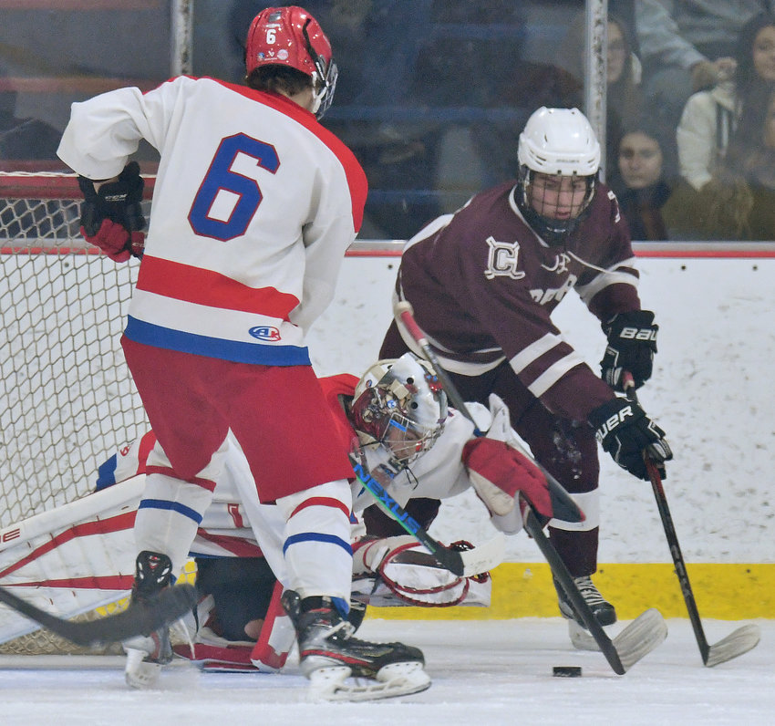 New Hartford goalie Rocco Mastrovito-Smith dives on the puck in front of Clinton&rsquo;s Caden Hinderling and New Hartford&rsquo;s Liam Bubnis in the first period in New Hartford Wednesday night. Clinton scored both third period goals for a 3-2 comeback win. Hinderling scored and had an assist in the win.