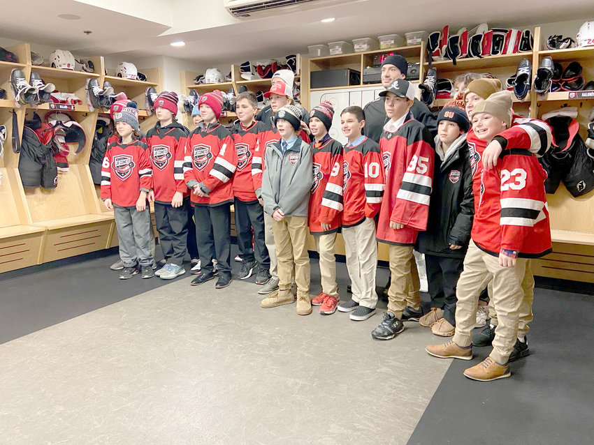 The Utica Jr. Comets pose with Utica Comets players Nick Hutchison and Samuel Laberge during a short sendoff event at the Adirondack Bank Center in Utica Saturday. The Jr. Comets team is headed to the Quebec International Pee-Wee Tournament Thursday for a little over a week of games.