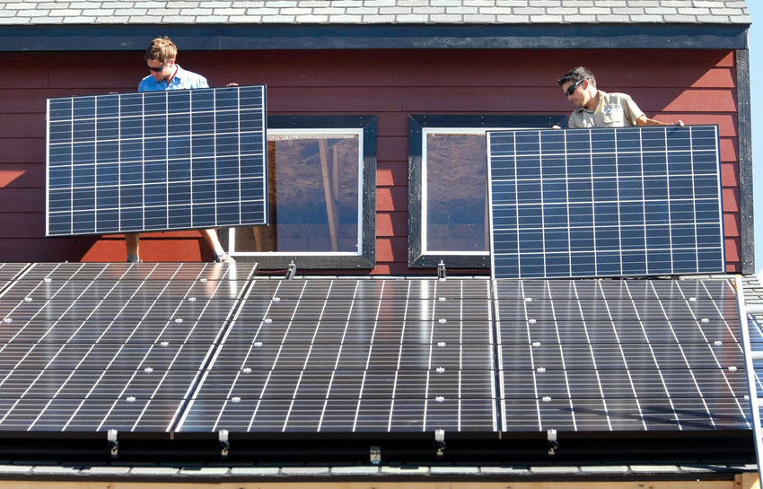 Workers install two of 105 solar panels on the roof of a barn in this AP file photo. The Inflation Reduction Act includes tax credits and rebates for homeowners who make energy-saving updates to their homes. Tax credits are available now for updates like new windows, doors, air conditioners, insulation and solar panels.