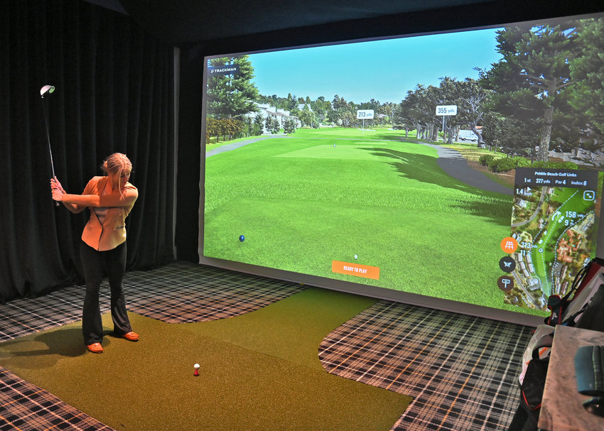 Rachele Potaczala, general manager at The Bunker Bar &amp;amp; Grill at 8653 Clinton St. in New Hartford, demonstrates one of the suites that guests can play rounds of golf in.