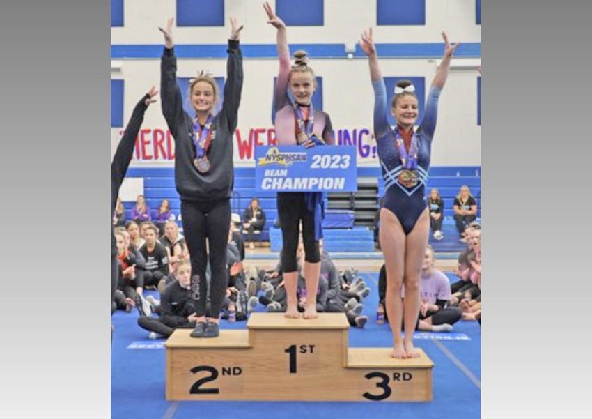 New Hartford&rsquo;s Grayson Gall stands on the podium in first place for the balance beam at the state gymnastics meet. Gall won the beam and bars and was second in the all-around. With her are Mya Wozniak of Section VI, left, and Hannah Hughes of Section XI, who won the all-around title.