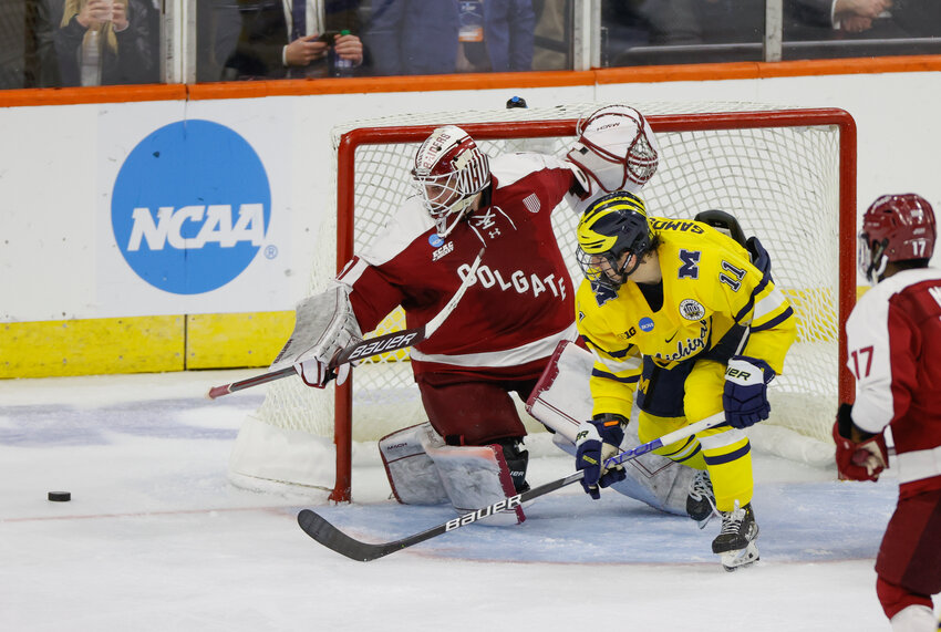 Colgate goalie Carter Gylander, left, and Michigan's Mackie Samoskevich battle for the puck during an NCAA tournament game on Friday in Allentown, Pennsylvania. Michigan won 11-1.
