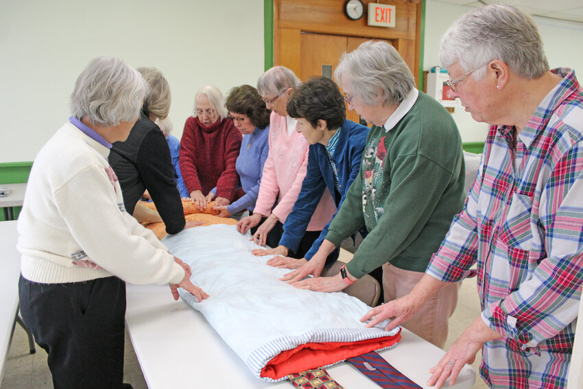 Members of My Brothers&rsquo; Keeper quilt group pray before tying up a sleeping bag at Dryden United Methodist Church, where they meet every Friday.