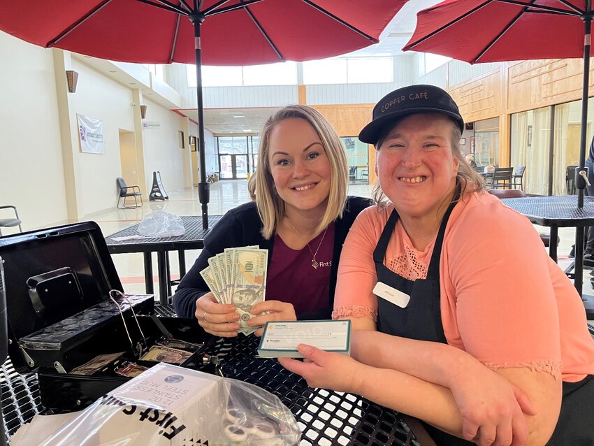 Allison Perry, right, a Copper Caf&eacute; employee supported by Arc Herkimer, learns financial literacy from Cristina Ferdinand, First Source community educator. The credit union recently awarded an additional $5,000 to the Arc Herkimer and its Copper Caf&eacute;.