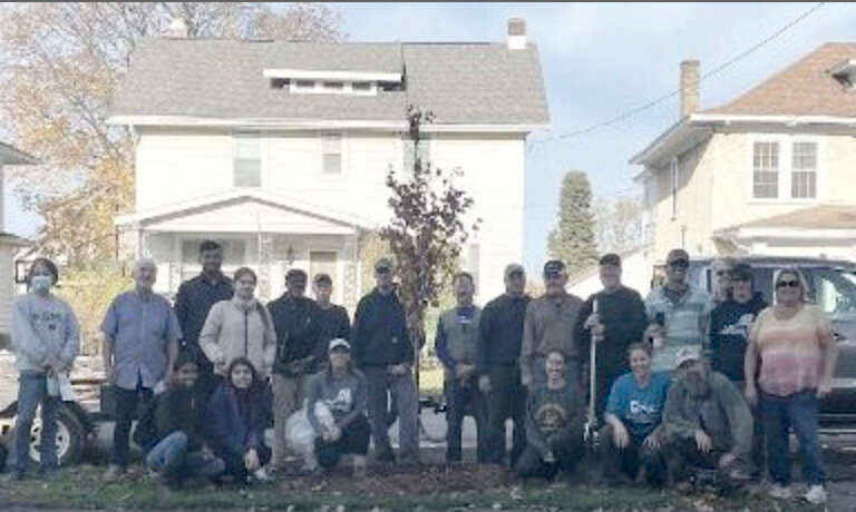 Volunteers pause from their efforts of planting 26 new trees in Utica&rsquo;s neighborhoods for a photo in this file photo from last fall.