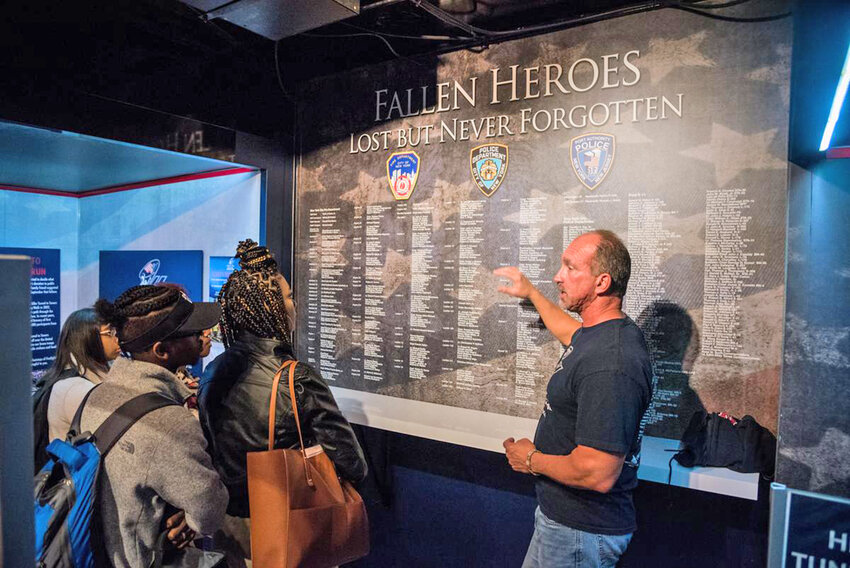 A former New York City firefighter acts as a tour guide at the 9/11 Never Forget Mobile Exhibit.