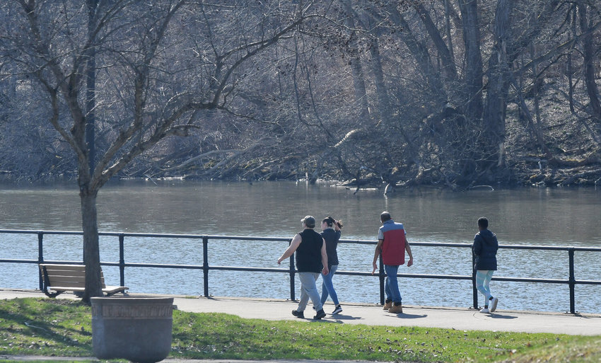 People walk along the promenade at Bellamy Harbor Park along the Erie Canal Trailway in Rome on Thursday April 13. A recent report says the popular trail system has received more than 10 million visits since the start of the COVID-19 pandemic.