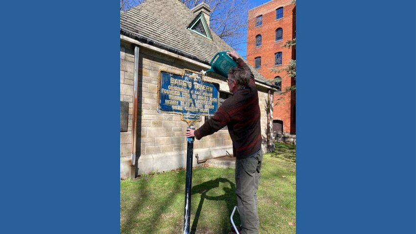 A volunteer cleans off the historic marker for Bagg&rsquo;s Tavern in this file photo. The Oneida County History Center is looking for volunteers to help clean historic markers during the third annual National Historic Marker Day on Friday, April 28, at 4 p.m. Volunteers will meet in Clinton before heading out to clean markers in the region.