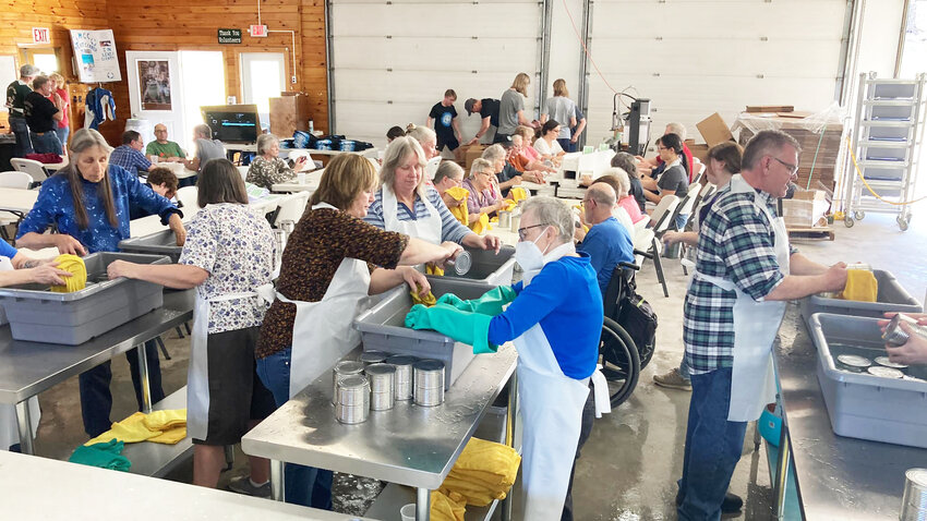 Volunteers at the 2023 Lewis County Meat Canner Project washing, drying, labeling and weighing&nbsp;cans of meat. Over the course of two days, Lowville volunteers helped prepare more than 10,000 cans of meat to be distributed internationally.