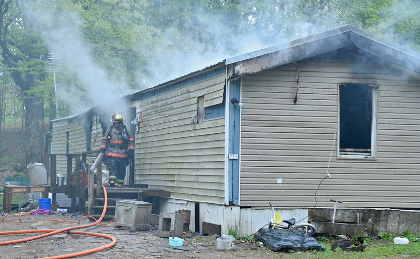 Smoke pours off the top of the mobile home at 3270 Pond Hill Road in Annsville on Tuesday. Fire officials said no one was hurt and a family of four have been displaced. The cause remains under investigation.