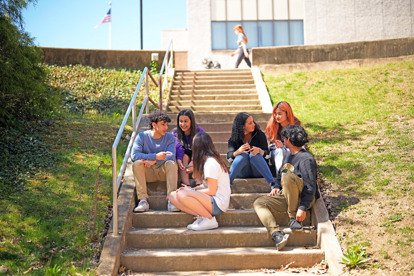 Upper Darby High School students Rayan Hansali, from left, Tanveer Kaur, Elise Olmstead, Fatima Afrani, Joey Ngo and Ata Ollah, talk in the campus courtyard, Wednesday, April 12, in Drexel Hill, Pa. For some schools, the pandemic allowed experimentation to try new schedules. Large school systems including Denver, Philadelphia and Anchorage, Alaska, have been looking into later start times.