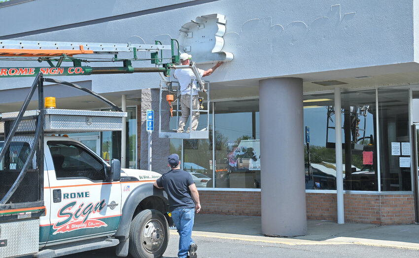 Workers with Rome Sign Co. install an OTB sign on the company&rsquo;s new location at the Westgate Plaza, on Erie Blvd. West, on Monday, May 15.