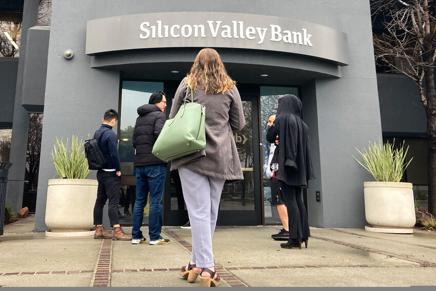 People stand outside a Silicon Valley Bank branch in Santa Clara, Calif., on March 10, 2023. The recent collapse of a trio of midsize banks, including Silicon Valley Bank, has once again raised questions on whether executive compensation is tilted toward short-term gains rather than companies' long-term health.