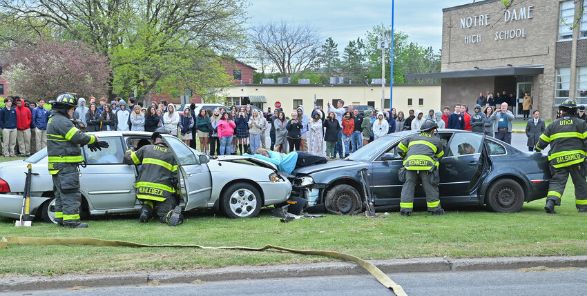 Utica firefighters check on student actors as their classmates and school staff watch Wednesday, May 17 at Notre Dame Junior/Senior High School in Utica. The Mock DWI Crash scene gave an up-close look at the potential tragic consequences of drunk driving.