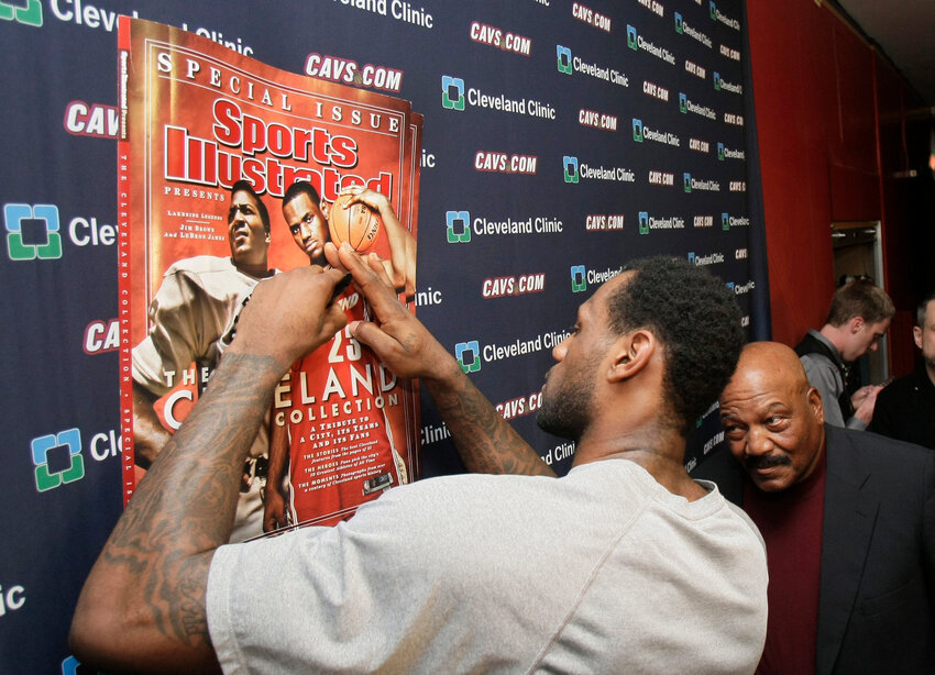 Cleveland Cavaliers' LeBron James, left, signs a copy of a Sports Illustrated cover as former Cleveland Browns football player Jim Brown watches, before an NBA game between the Cavaliers and the Toronto Raptors on Jan. 19, 2010, in Cleveland. The cover featured both James and Brown for the &quot;Lakeside Legends&quot; issue. &ldquo;I hope every Black athlete takes the time to educate themselves about this incredible man and what he did to change all of our lives,&rdquo; James posted shortly after Brown's death. &rdquo;We all stand on your shoulders Jim Brown. If you grew up in Northeast Ohio and were Black, Jim Brown was a God.&quot;