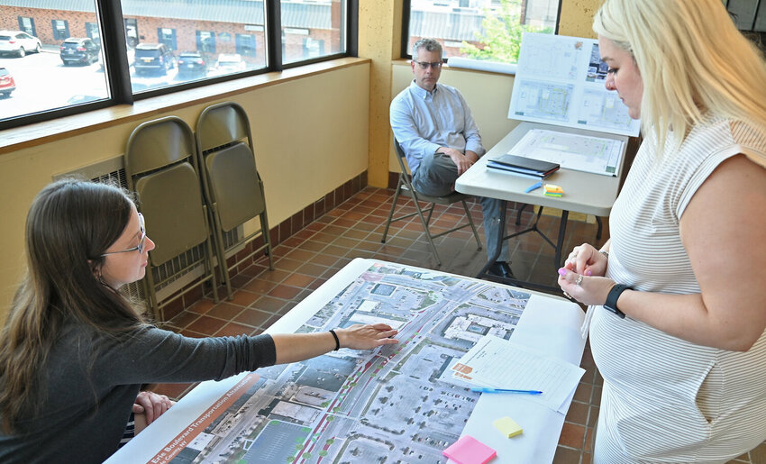 Rome Marketing and Special Events Coordinator Sarah Lokker, right, looks over the plans for Erie Boulevard improvements with city planner Danielle Salisbury. The plans for three upcoming city projects are on display this week at City Hall. In the background is Julian Clark of Plumley Engineering, who will answer questions about the new parking lot on North James Street.