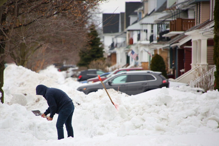 A person removes snow from the front of his driveway a few days after a winter storm rolled through western New York Thursday, Dec. 29, 2022, in Buffalo, N.Y. A new report finds several shortcomings in Buffalo's response to a historic December blizzard in which 31 city residents died. The report was released Friday, June 2, 2023, by the New York University Wagner School for Public Service.